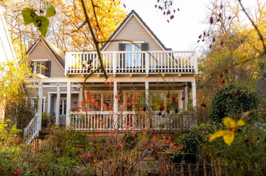 Haus im New England Holz-Stil  im herbstlichen Garten mit bunten Blättern.