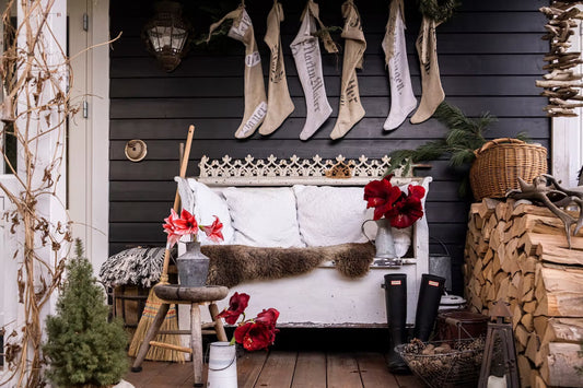 Winterliche Dekoration mit roten und weißen Amaryllis, Holzbank und Weihnachtsstrümpfen