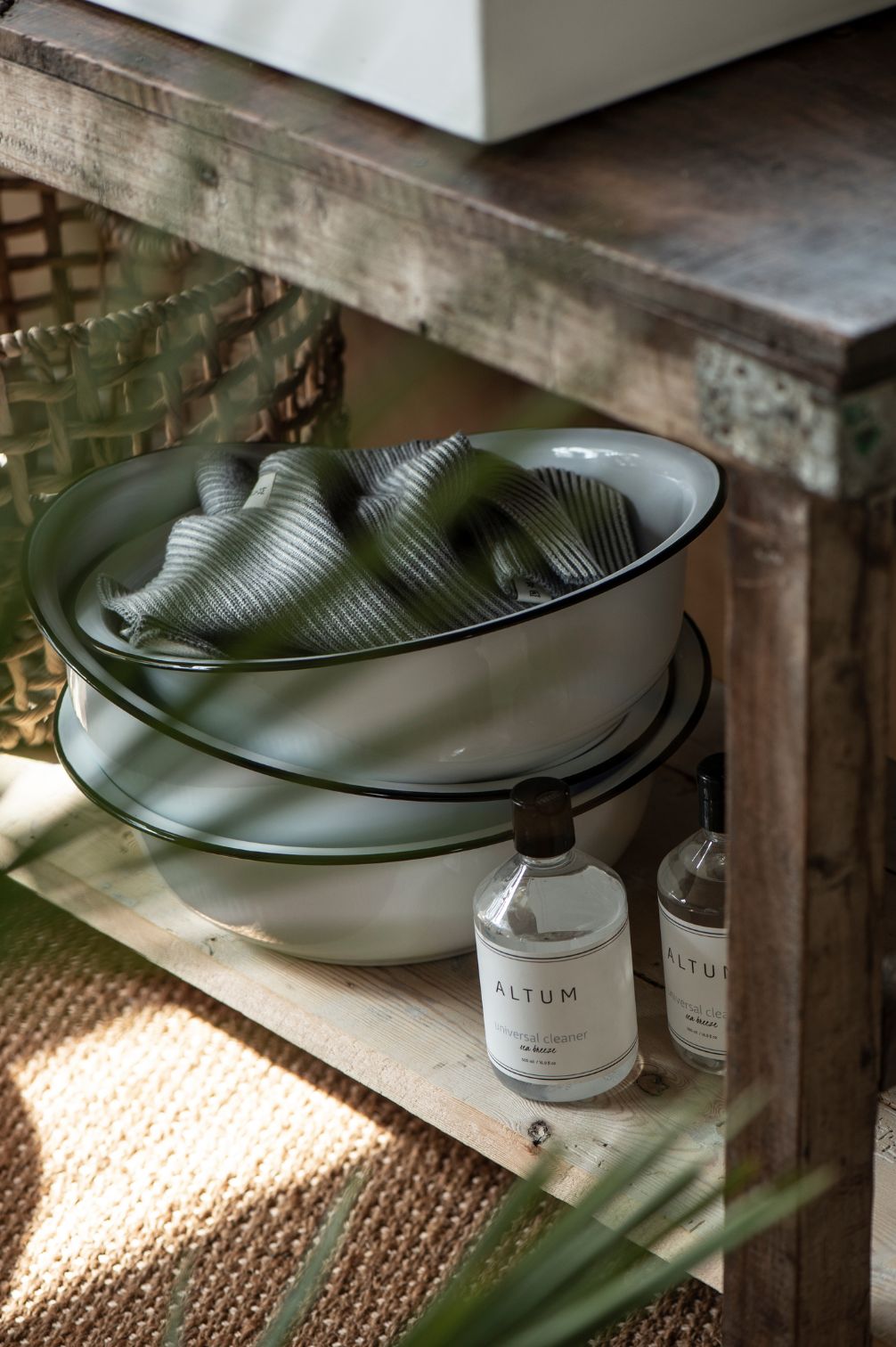 Detailansicht einer weißen Emaille-Schüssel mit schwarzem Rand auf Holzkonsole.