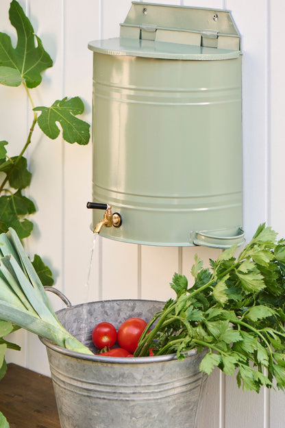 Konischer Metalltopf aus verzinktem Material mit Henkeln als Pflanzgefäß im Garten.