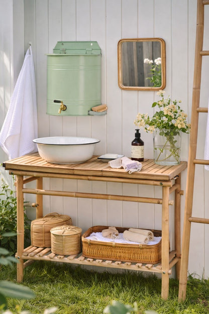 Wand-Wasserbehälter aus Metall in pastellgruen mit Hahn als stilvolle Outdoor-Waschstation im Cottage-Garten.