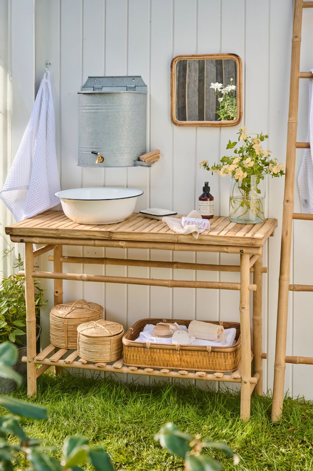 Wand-Wasserbehälter aus Metall mit Hahn als stilvolle Outdoor-Waschstation im Cottage-Garten.